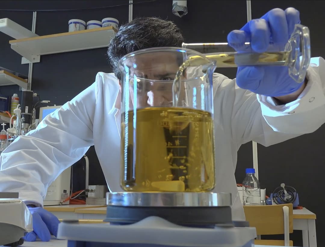 en man häller matolja i laboratorieglas