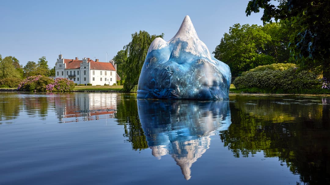 Ett uppblåsbart fjäll flyter på vattnet framför ett slott