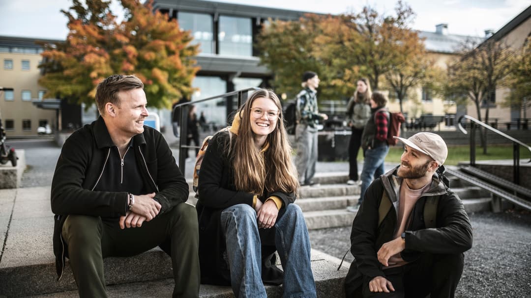 Tre studenter som sitter i en trappa utanför Campus Östersund