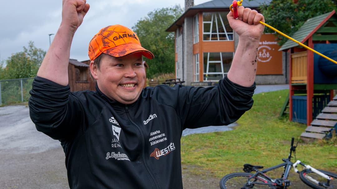 En leende man som gör en vinnargest.