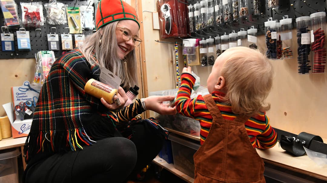 En kvinna och ett litet barn ser på slöjdmaterial i en butik