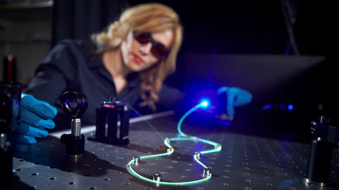 Enkeleda Balliu working with laser and fiber optic in the lab