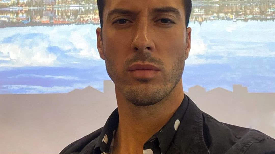 A portrait photo of a man with short dark hair