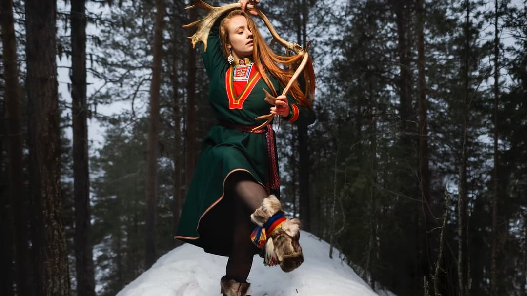 En kvinna i grön kolt som dansar på en snöhög