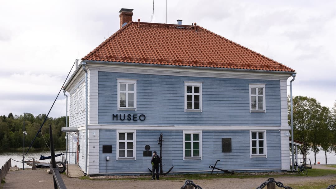 Ljust blått trähus med vita knutar och tegeltak. På fasaden står Museo. 