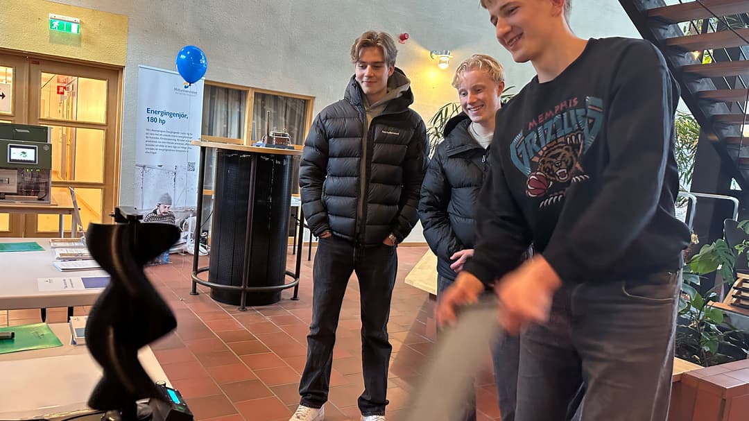 Tre män tittar på ett bord.