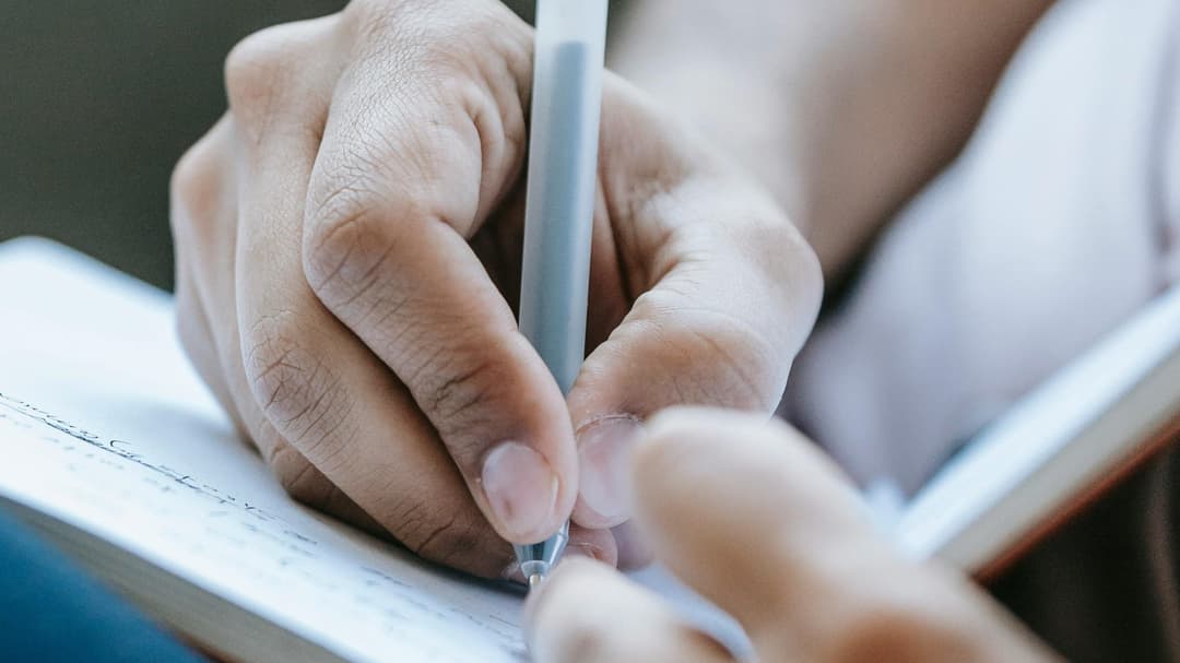 Hands writing on paper