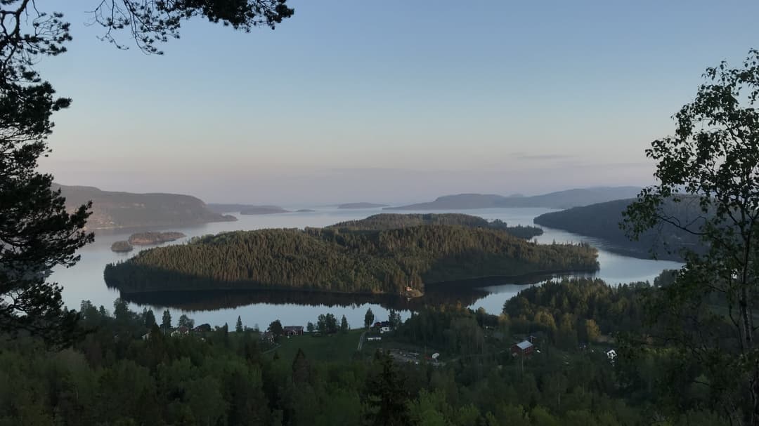 Utsikt över skogsklädda öar i stilla vatten.