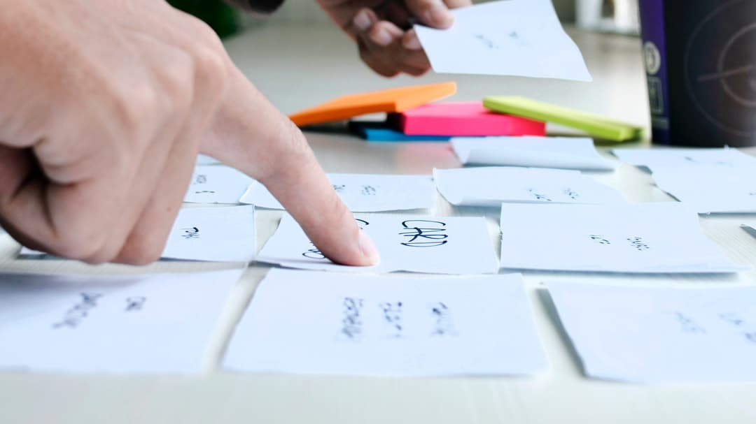 Two hands who arrange post it patches on a table