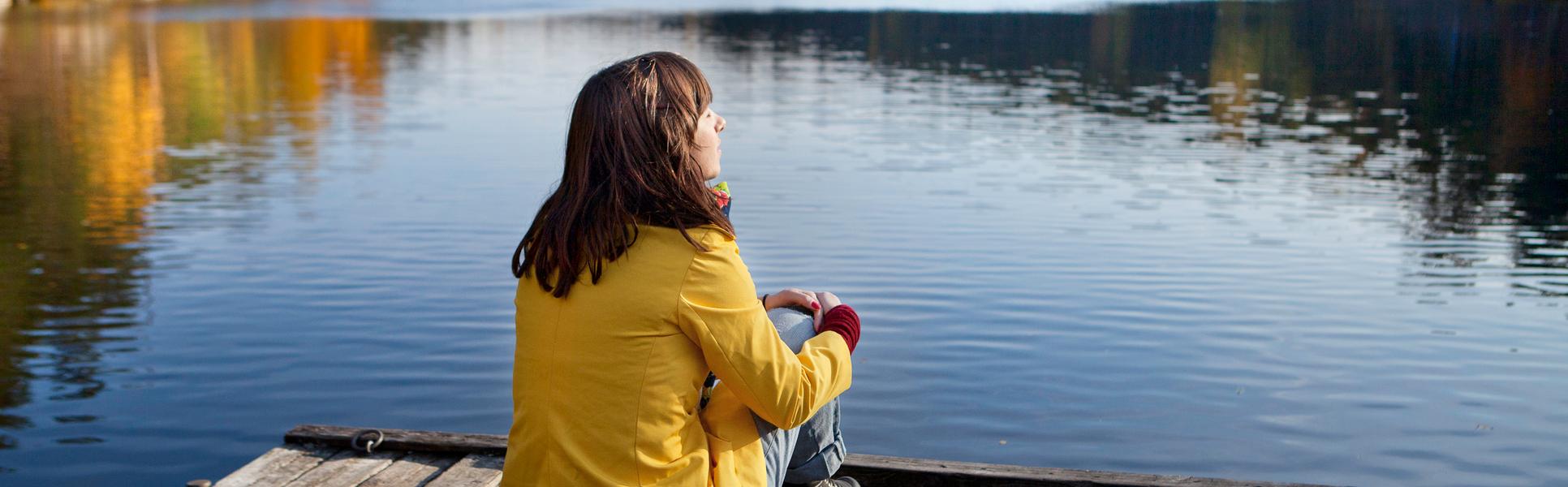naturturist - en kvinna som sitter på en brygga.