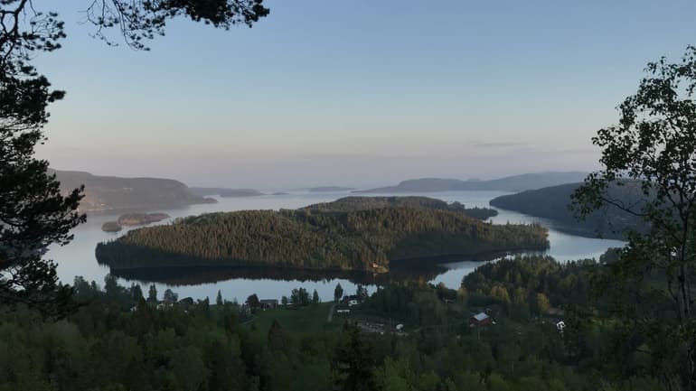 Utsikt över skogsklädda öar i stilla vatten.