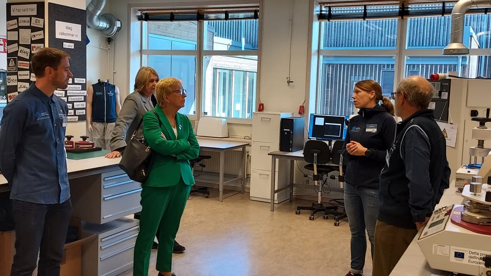Tre kvinnor och två män vid förevisning av labb på campus Östersund