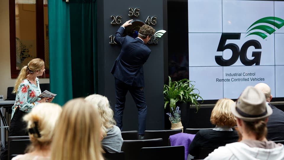 Man turning a big switch to launch 5G.