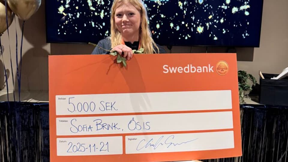 Person som visar upp prispengar kort från Swedbank.
