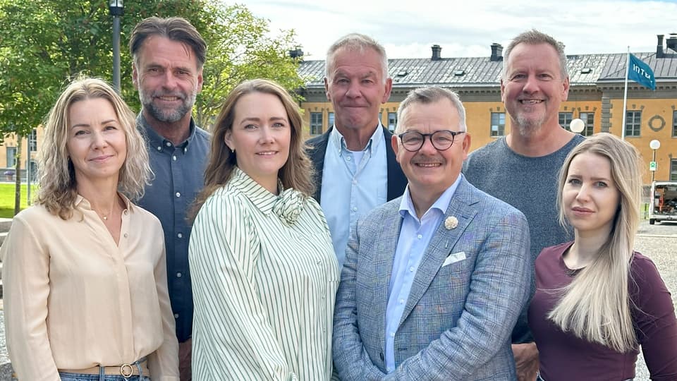 En gruppbild med sju personer utomhus.