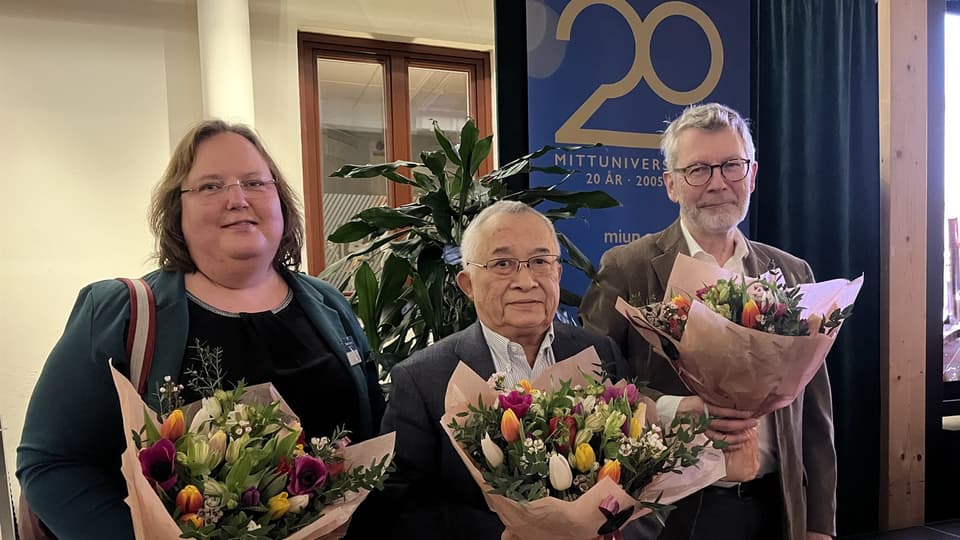 Tre personer med varsin stor blombukett står bredvid varandra.