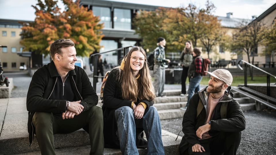 Tre studenter som sitter i en trappa utanför Campus Östersund
