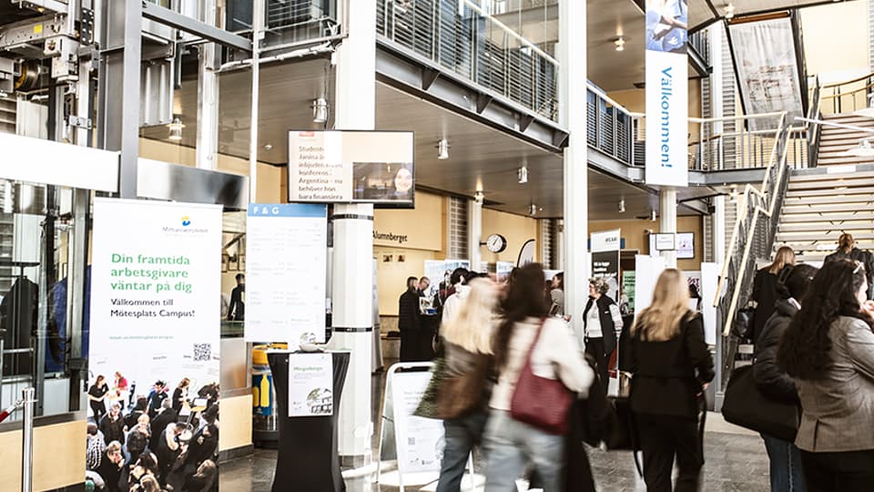 Students i Ljushallen in Östersund and a roll up with information about Mötesplats Campus