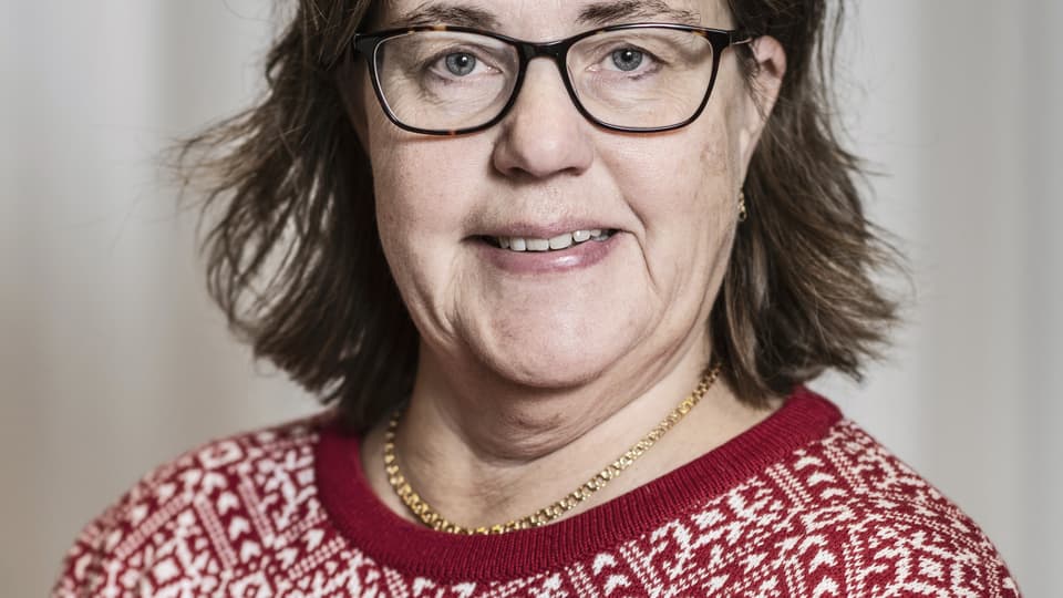 En kvinna med mörkt hår och glasögon