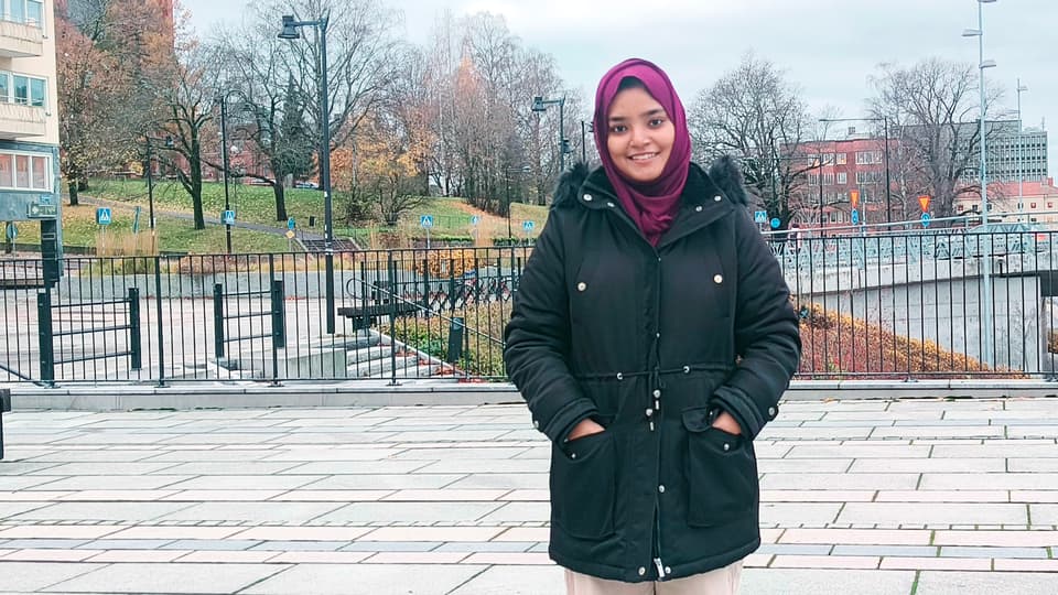 en kvinna står i stadsmiljö
