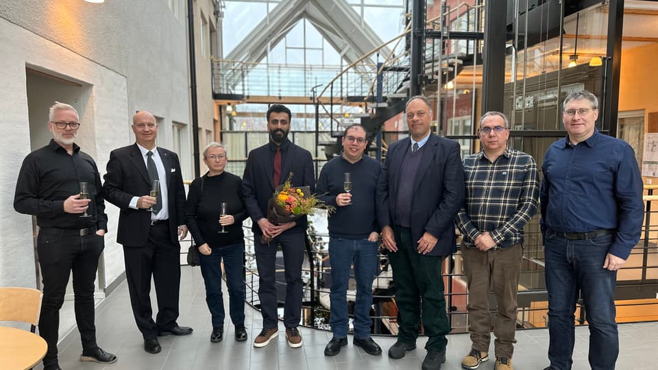 En gruppbild med åtta finklädda personer