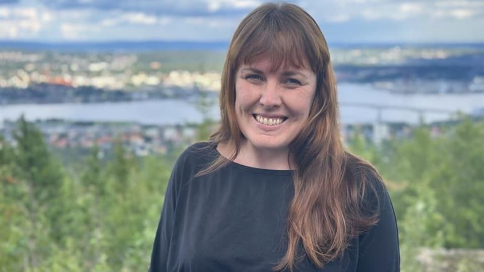 Kvinna med långt brunt hår och en svart tröja