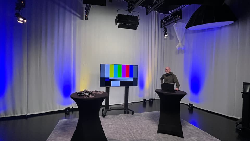 Man står vid ett av två ståbord i en TV-studio