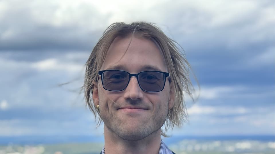 En man med blå kavaj och glasögon