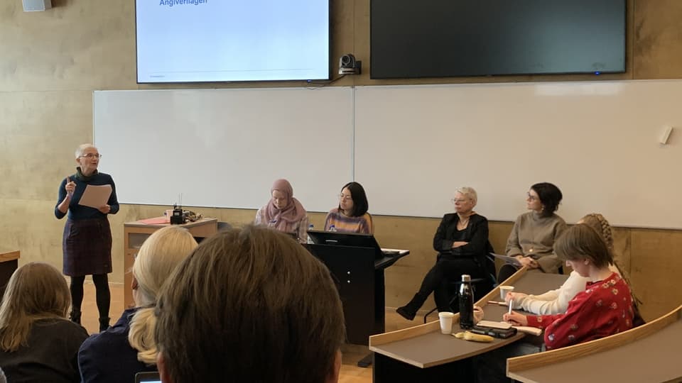 Fem personer i en panel framför åhörare i seminariesal.