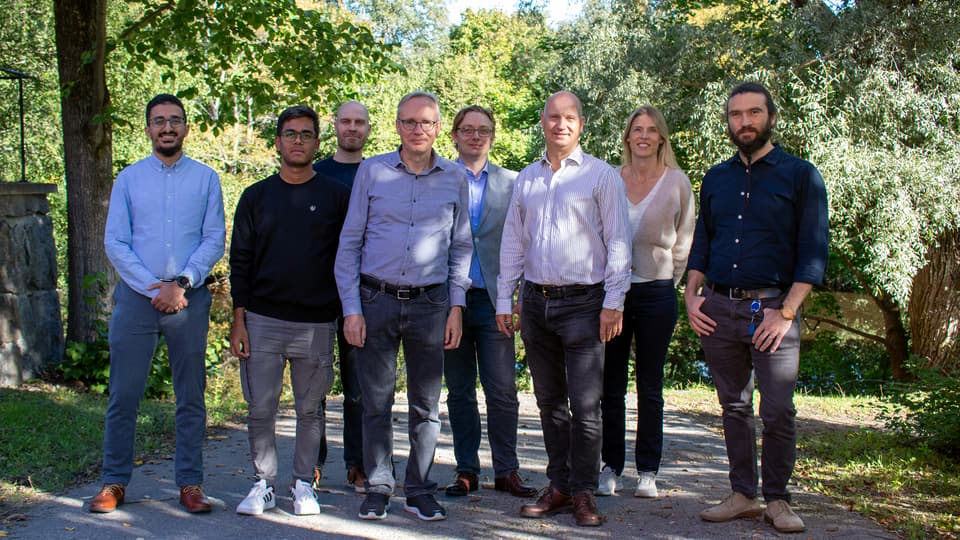 A group picture with eight people, one woman and the rest men.