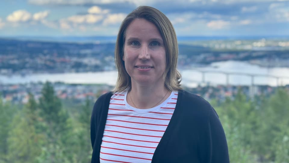 Kvinna med brunt hår och en röd/vit-randing tröja
