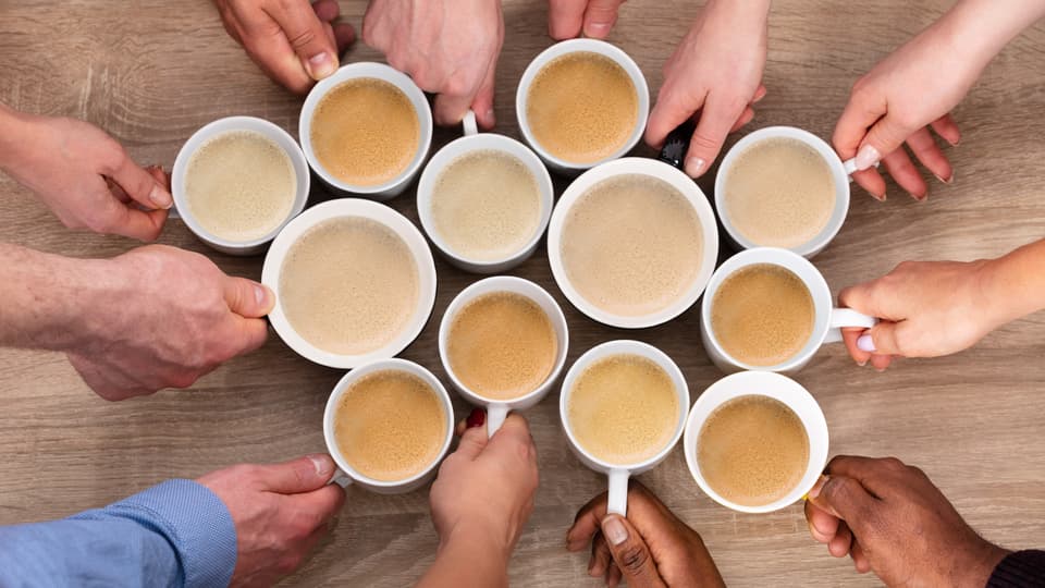 Händer håller i kaffekoppar