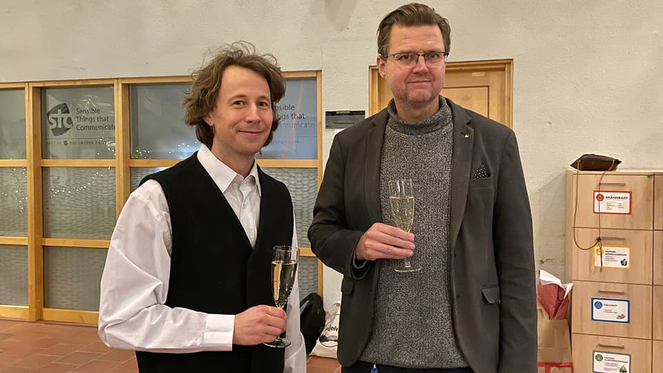 Två män skålar framför kameran.