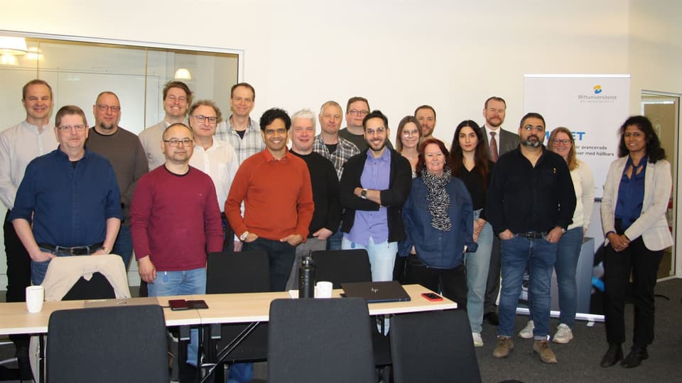 En grupp personer står tillsammans i ett konferensrum.