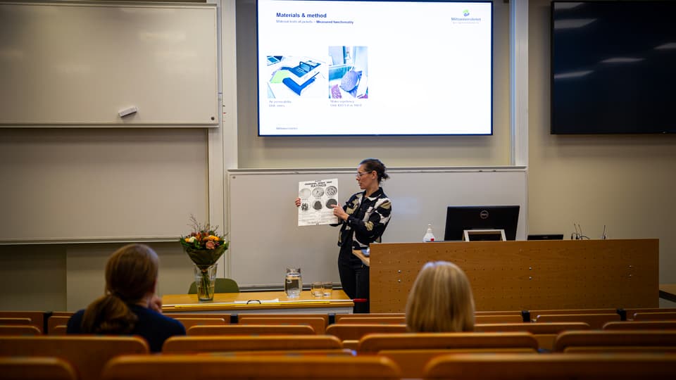 En kvinna står i en lektionssal.