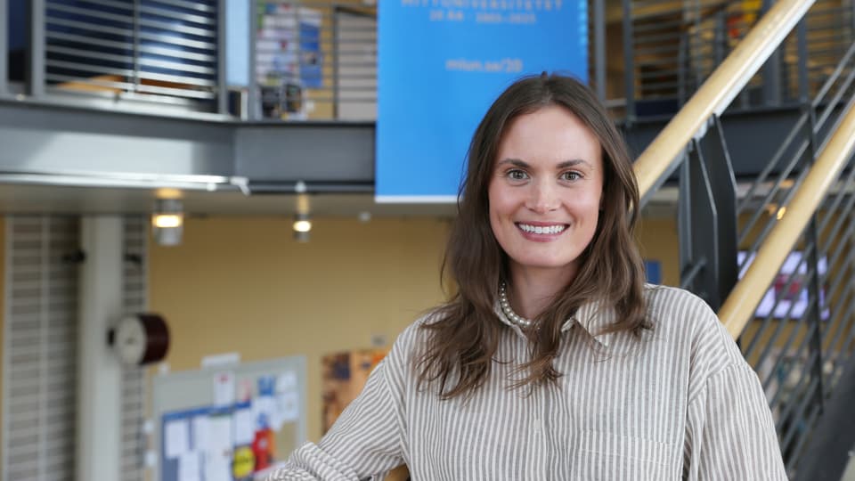 Leende kvinna i trappa inomus.