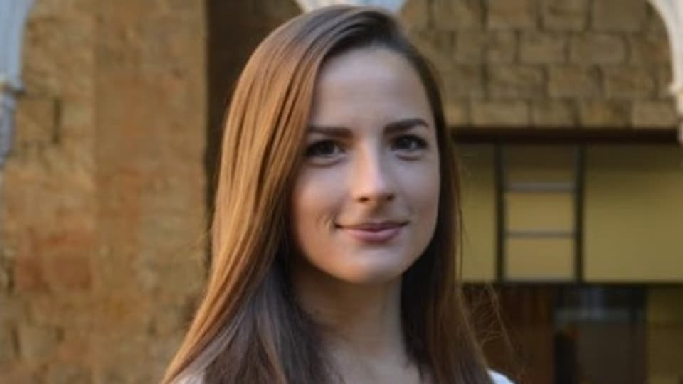A woman with brown hair smiles at the camera