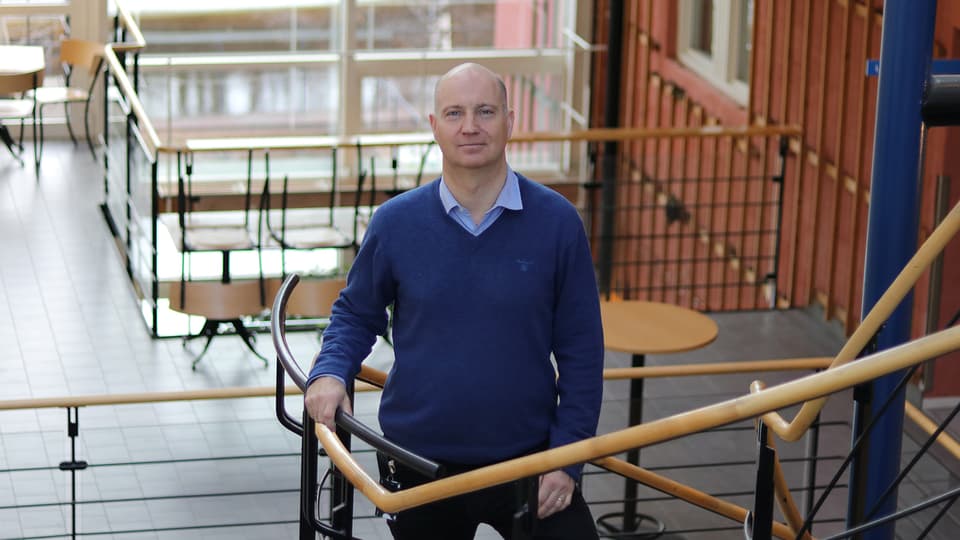 Mårten Sjöström står i trapphuset på campus.