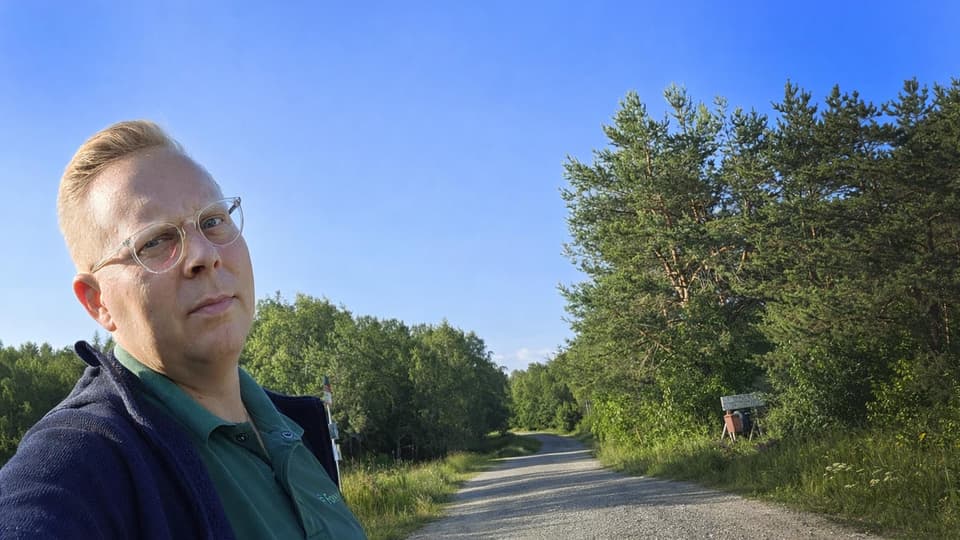 En man står vid en grusväg.