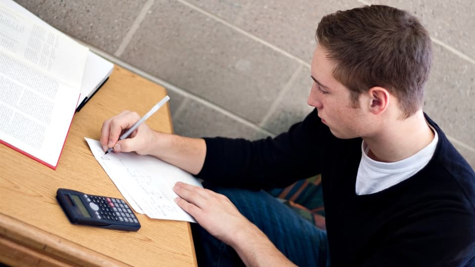 Student sitter och räknar matte.