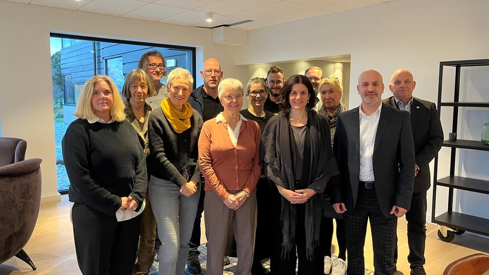 En grupp människor står framför ett fönster.