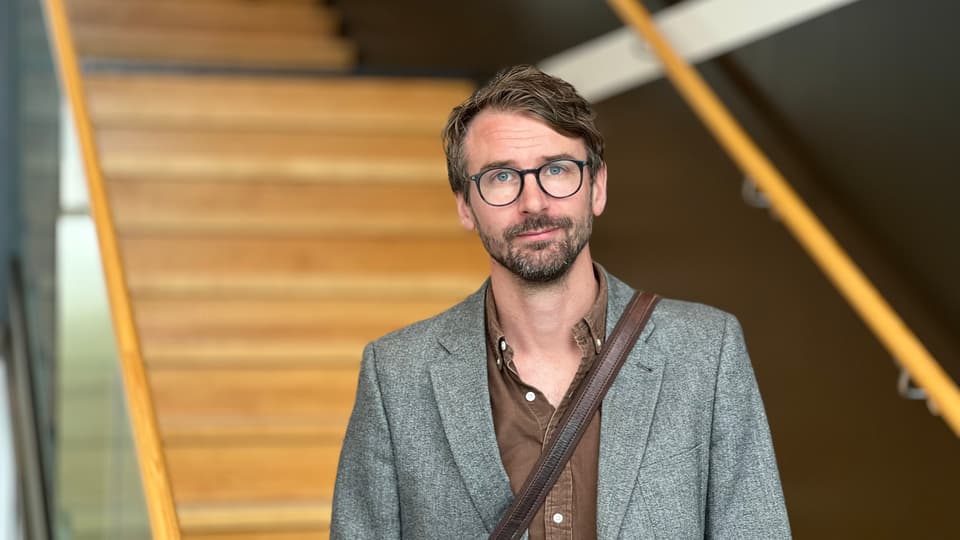 En man med glasögon ståendes i en trappa