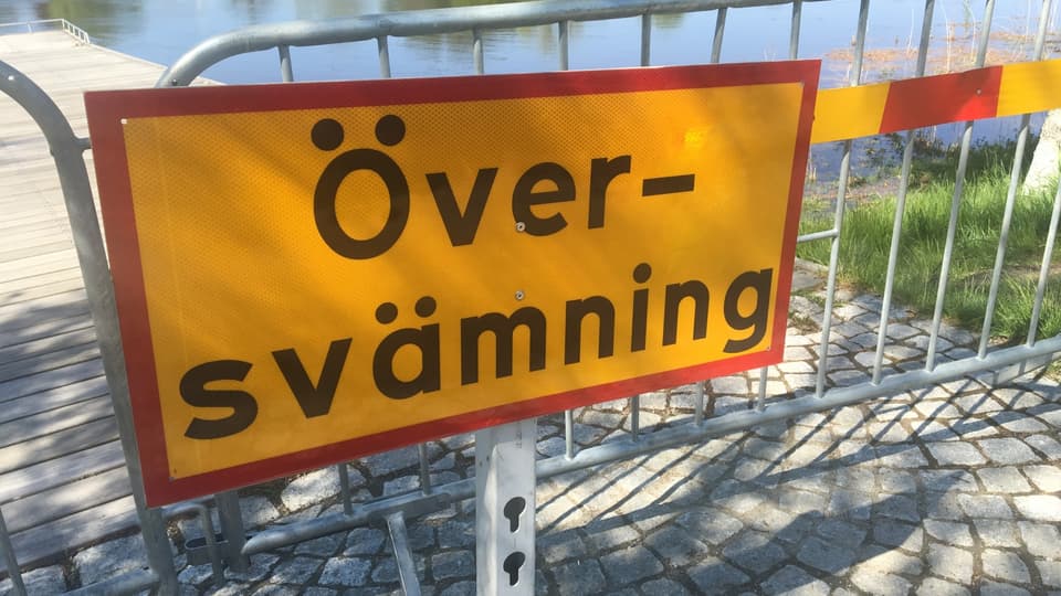 Gul skylt med texten "Översvämning" i svart