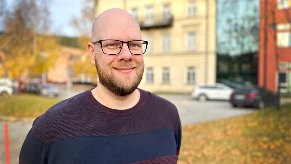 Man med glasögon står utomhus.