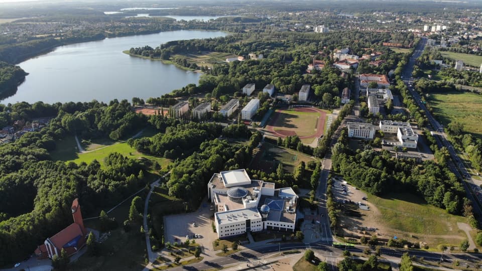 Översiktsbild skog, byggnader och vatten