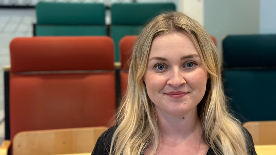 Ett porträttfoto av en blond kvinna med hår över axlarna